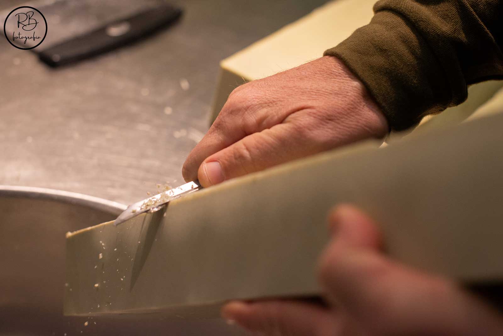 Manos perfilando los cantos de las pastillas de jabón natural de Mallorca